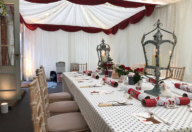Christmas House Extension Marquee with crackers and festive lighting decorating the table