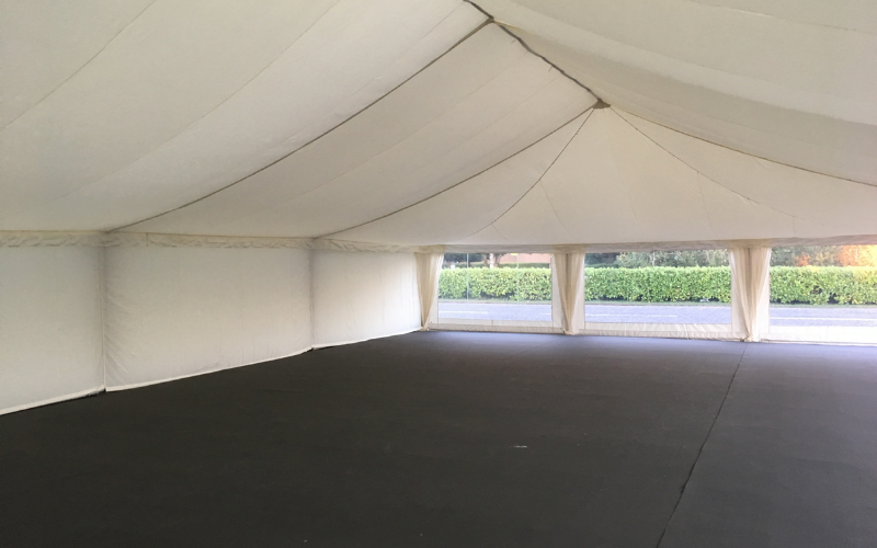 Hollow white event marquee with black hard flooring and clear walls to reverse
